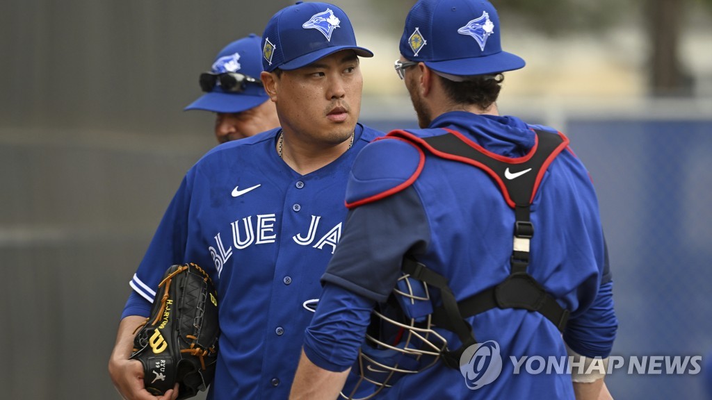 In this Canadian Press photo via the Associated Press, Ryu Hyun-jin of the Toronto Blue Jays (L) talks with catcher Danny Jansen after a bullpen session during spring training at the team's Player Development Complex in Dunedin, Florida, on March 16, 2022. (Yonhap)