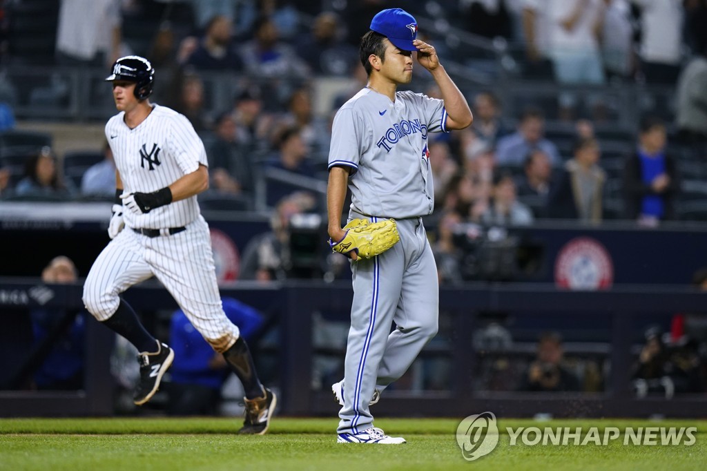In this Associated Press photo, Yusei Kikuchi of the Toronto Blue Jays (R) reacts to a two-run home run by Aaron Hicks of the New York Yankees during the bottom of the second inning of a Major League Baseball regular season game at Yankee Stadium in New York on April 12, 2022. (Yonhap)