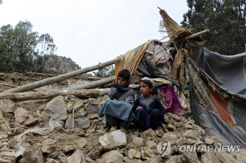 아프가니스탄 호스트주의 한 마을에서 지진으로 무너진 집 앞에 앉아있는 아이들