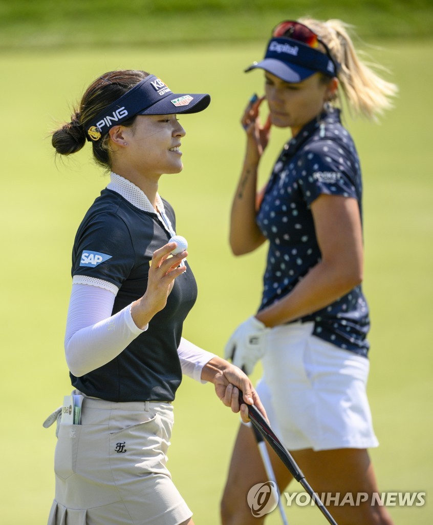 In this Associated Press photo, Chun In-gee of South Korea (L) reacts to her par putt as Lexi Thompson of the United States passes by on the 17th green during the final round of the KPMG Women's PGA Championship at the Congressional Country Club's Blue Course in Bethesda, Maryland, on June 26, 2022. (Yonhap)