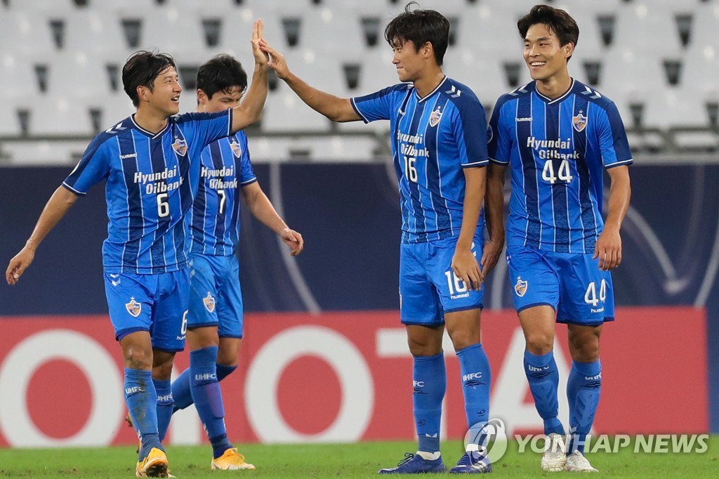 In this AFP photo, Won Du-jae of Ulsan Hyundai FC (2nd from R) high-fives teammate Park Joo-ho after scoring a goal against Melbourne Victory during the teams' round of 16 match at the Asian Football Confederation Champions League at Education City Stadium in Al-Rayyan, Qatar, on Dec. 6, 2020. (Yonhap)