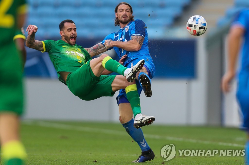 In this AFP photo, Dave Bulthuis of Ulsan Hyundai FC (R) battles Renato Augusto of Beijing Guoan for the ball during the teams' quarterfinals match at the Asian Football Confederation Champions League at Al Janoub Stadium in Al Wakrah, Qatar, on Dec. 10, 2020. (Yonhap)