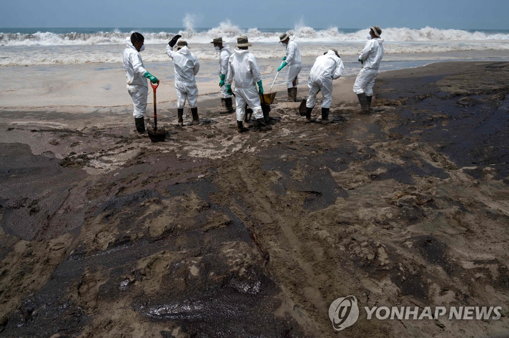 27일(현지시간) 기름 유출 해변 청소하는 페루 작업자들