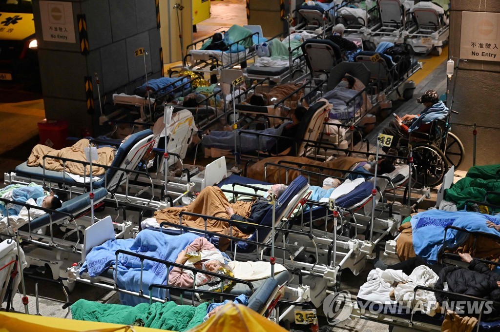 (AFP=연합뉴스) 지난 16일 홍콩의 카리타스 메디컬센터 바깥에서 코로나19 환자들이 이동식 침대에 누운 채 대기하는 모습. 2022.2.17.