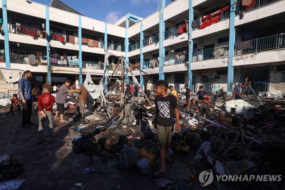 8일(현지시간) 가자지구 중부의 이스라엘 공습 현장 둘러보는 팔레스타인 피란민들