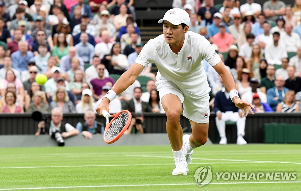 In this EPA photo, Kwon Soon-woo of South Korea hits a shot against Novak Djokovic of Serbia during their men's singles first round match at Wimbledon at All England Club in London on June 27, 2022. (Yonhap)