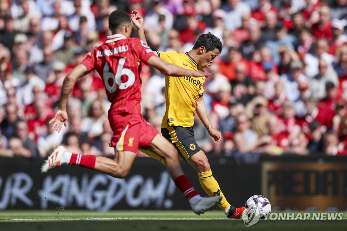 In this EPA photo, Hwang Hee-chan of Wolverhampton Wanderers (R) attempts a shot past Trent Alexander-Arnold of Liverpool during the clubs' Premier League match at Anfield in Liverpool, England, on May 19, 2024. (Yonhap)