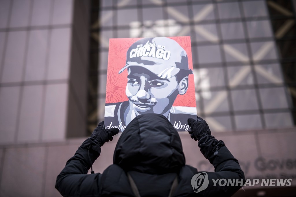 법원 앞에서 피해자의 초상을 들고 있는 시위자