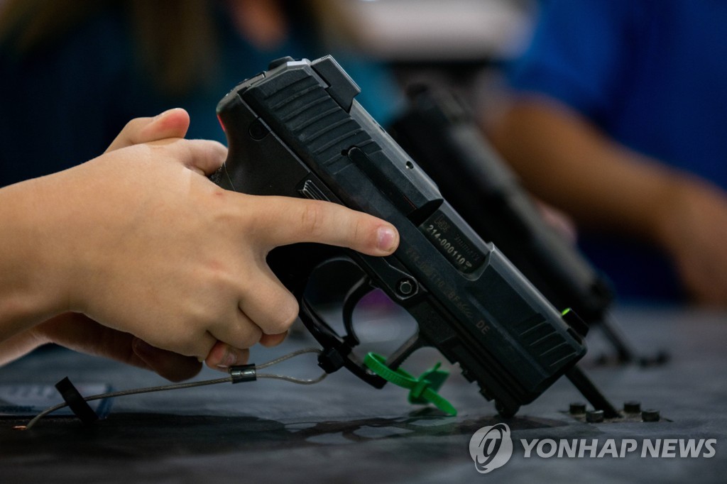 전미총기협회(NRA) 연례총회에서 권총을 쥐어보는 7살 어린이  [AFP 연합뉴스자료사진]