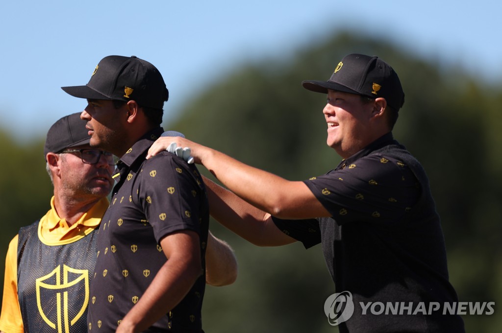 In this Getty Images photo, South Korean Im Sung-jae of the International Team (R) gives his Colombian teammate Sebastian Munoz a shoulder rub after Munoz's birdie on the 13th hole during their fourball match against Scottie Scheffler and Sam Burns of the United States at the Presidents Cup at Quail Hollow Club in Charlotte, North Carolina, on Sept. 23, 2022. (Yonhap)