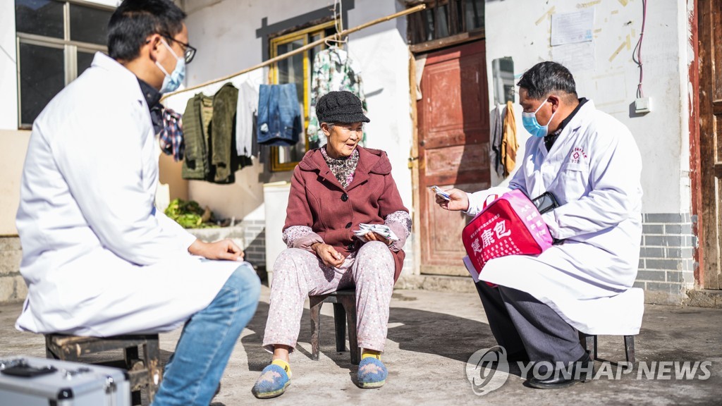 중국 의료진이 주민들에게 약을 건네는 모습