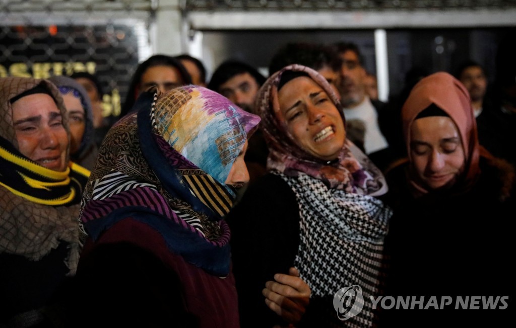 26일 터키 동부 엘라지에서 지진 피해자의 유족이 슬퍼하고 있다. [로이터=연합뉴스]