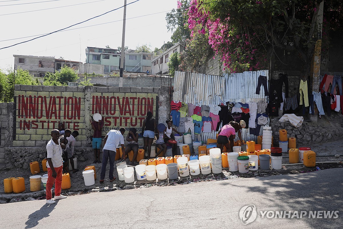 지난 12일(현지시간) 물을 받기 위해 기다리는 아이티 주민들