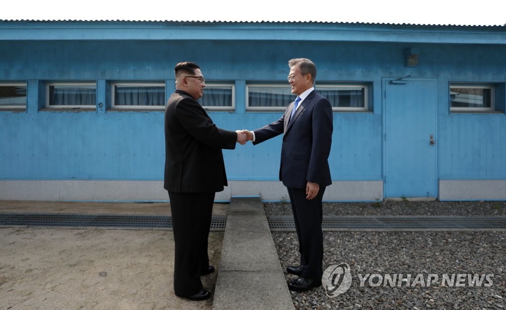 昨年４月、板門店で初対面した韓国の文在寅（ムン・ジェイン）大統領（右）と北朝鮮の金正恩（キム・ジョンウン）国務委員長（朝鮮労働党委員長）が軍事境界線をはさんで握手を交わしている（資料写真）＝（聯合ニュース）
