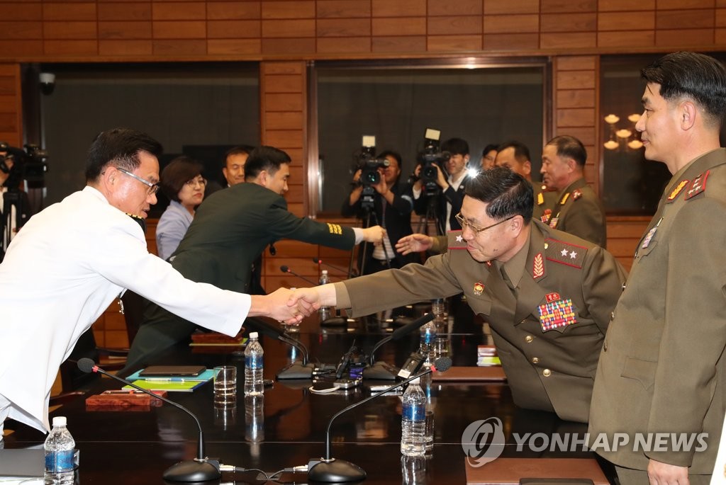 軍事境界線がある板門店の北朝鮮側施設で１４日に開かれた南北将官級軍事会談で、握手を交わす韓国代表（左）と北朝鮮代表（写真共同取材団）＝（聯合ニュース）