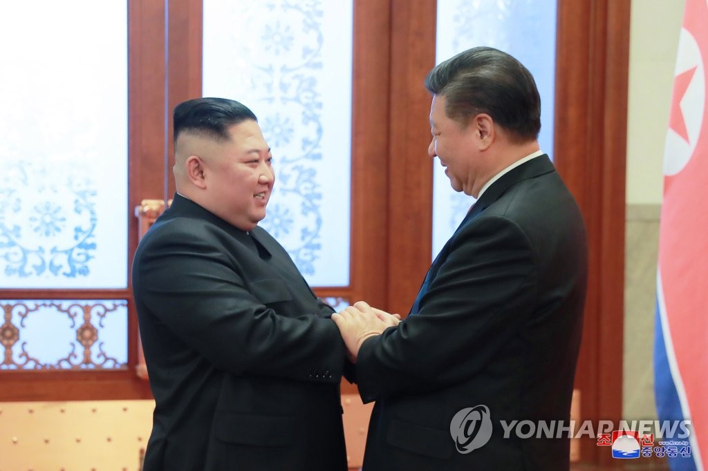 North Korean leader Kim Jong-un (L) and Chinese President Xi Jinping chat, holding their hands on Jan. 8, 2019, when Kim visited China in this file photo released by the North's official Korean Central News Agency on Jan. 10, 2019. (For Use Only in the Republic of Korea. No Redistribution) (Yonhap)