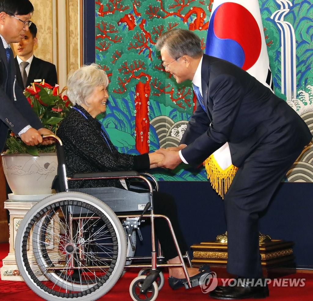 휠체어 탄 해외 독립유공자 후손 손 꼭 잡는 문 대통령 | 연합뉴스 휠체어 탄 해외 독립유공자 후손 손 꼭 잡는 문 대통령 | 연합뉴스