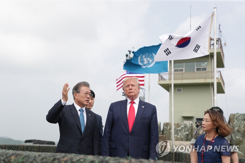 South Korean President Moon Jae-in (L) talks with U.S. President Donald Trump during their trip to the Demilitarized Zone on June 30, 2019, in this file photo. (Yonhap)