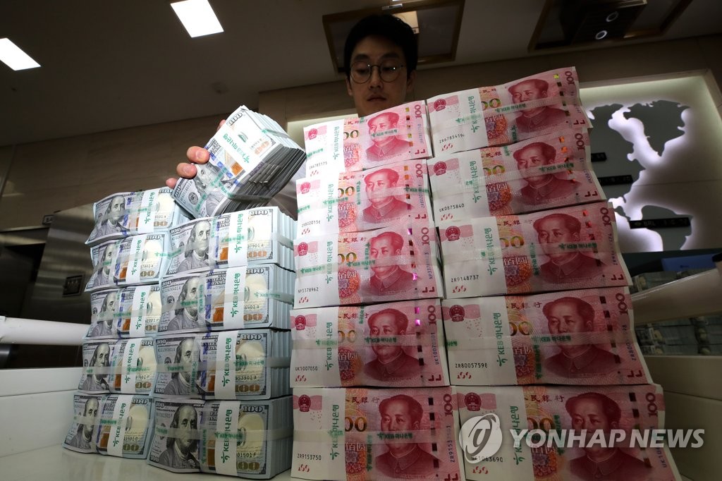 In the file photo, taken Aug. 5, 2019, a bank official inspects stacks of foreign currencies at a Seoul bank. (Yonhap)
