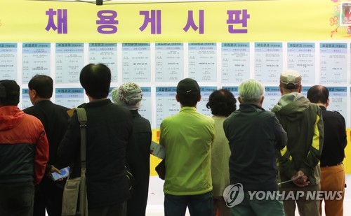 This file photo shows senior citizens reading job postings at a job fair for the elderly in Suwon, south of Seoul, on Oct. 15, 2019. (Yonhap)