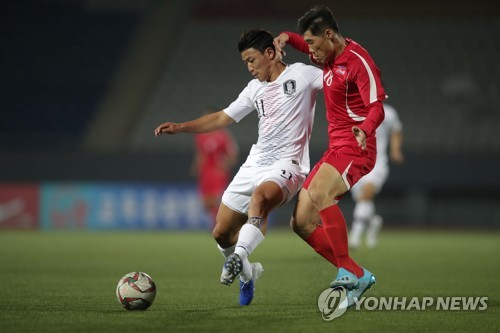 In this photo provided by the Korea Football Association, Hwang Hee-chan of South Korea (L) battles Ri Yong-chol of North Korea for the ball during the teams' World Cup qualifying match at Kim Il-sung Stadium in Pyongyang on Oct. 15, 2019. (PHOTO NOT FOR SALE) (Yonhap)
