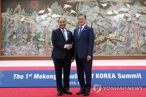 釜山で開かれた第１回韓国・メコン首脳会議の会場で握手を交わす文大統領（右）とフック首相＝２７日、釜山（聯合ニュース）