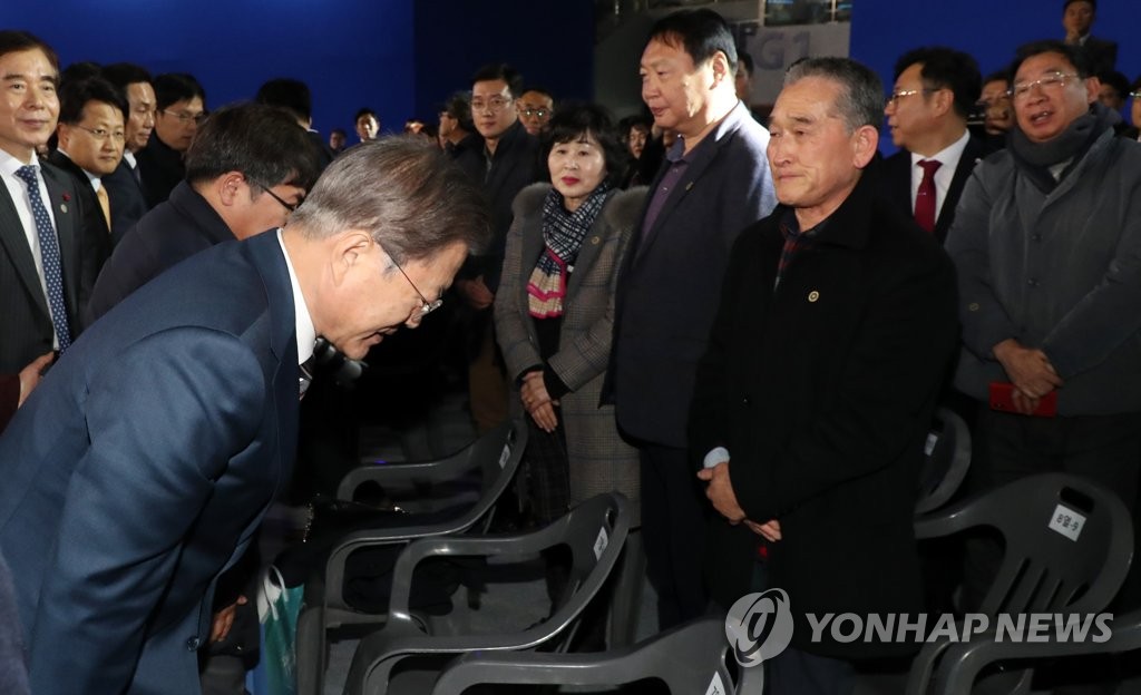 President Moon Jae-in (L) meets with victims of the 2017 Pohang earthquake attending an investment-related agreement signing ceremony in the southern city on Jan. 9, 2020. (Yonhap)