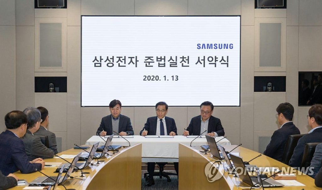 In this photo taken by Samsung Electronics Co. on Jan. 13, 2020, Samsung Electronics executives sign an oath of compliance at the company's office building in Suwon, south of Seoul. (PHOTO NOT FOR SALE) (Yonhap)