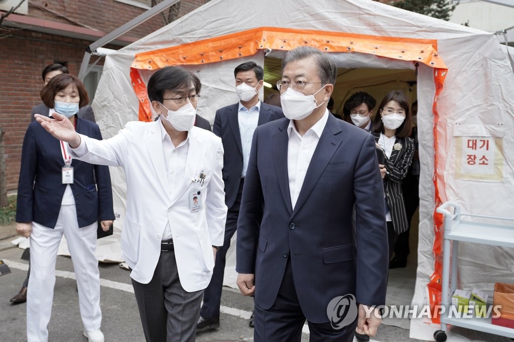 This file photo, dated Jan. 28, 2020, shows President Moon Jae-in (R) visiting the National Medical Center in Seoul to inspect its response to the outbreak of a new coronavirus. The photo was released by Cheong Wa Dae. (PHOTO NOT FOR SALE) (Yonhap)