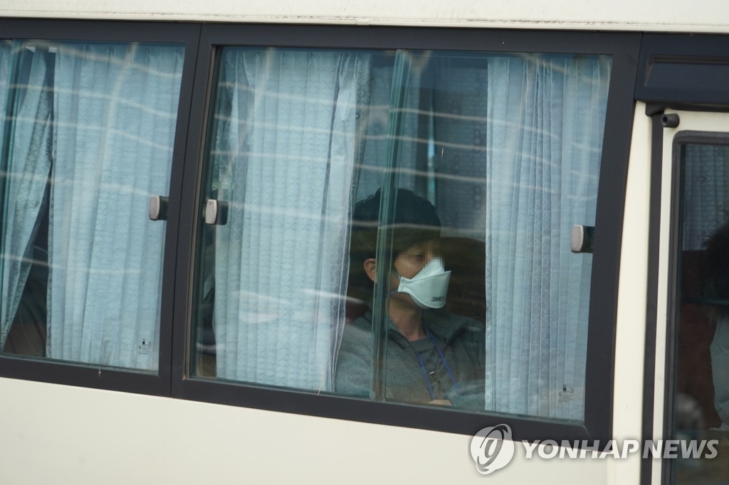 A South Korean citizen, airlifted from the coronavirus-hit Chinese city of Wuhan, rides in a bus bound for a quarantine facility in central South Korea on Feb. 1, 2020. (Yonhap)
