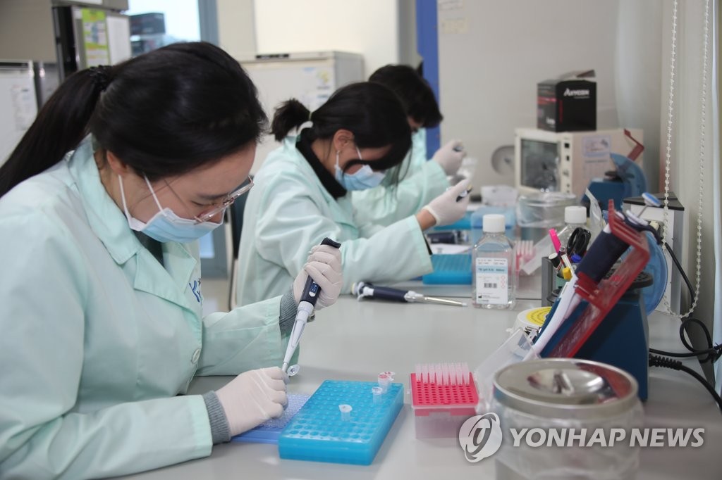 In this file photo taken Feb. 5, 2020, researchers at Kogene Biotech Co. conduct tests on its reagent at its laboratory in Seoul. (Yonhap)