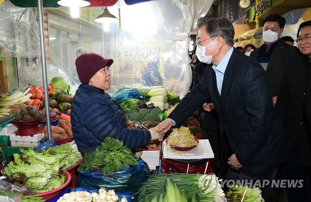 President Moon Jae-in (R) shakes hands with a merchant at the Onyang traditional market in Asan, South Chungcheong Province, on Feb. 9, 2020. (Yonhap) 