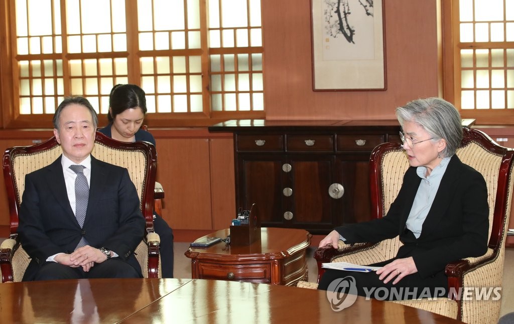 Foreign Minister Kang Kyung-wha (R) speaks with Japanese Ambassador to South Korea Koji Tomita at the foreign ministry in Seoul on March 6, 2020, after she called in the envoy in protest of Tokyo's decision to impose entry restrictions on arrivals from South Korea. (Yonhap)