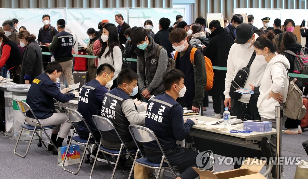 In this file photo taken on March 16, 2020, passengers arriving from Paris undergo special entry procedures at Incheon International Airport, west of Seoul. (Yonhap)