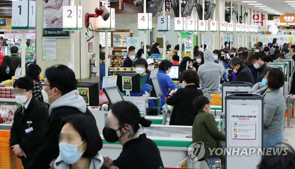This file photo shows shoppers wearing protective masks at a supermarket in Seoul on March 22, 2020. (Yonhap)