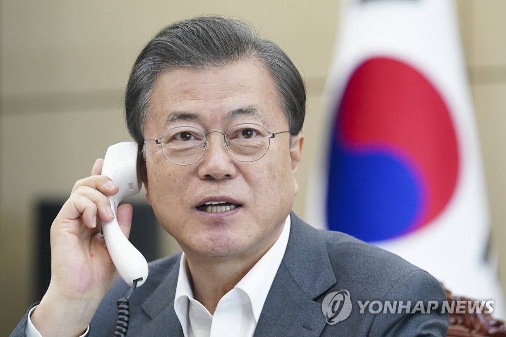 This file photo, provided by Cheong Wa Dae, shows President Moon Jae-in speaking on the phone with WHO Director-General Tedros Adhanom Ghebreyesus at his office in Seoul on April 6, 2020. (Yonhap)