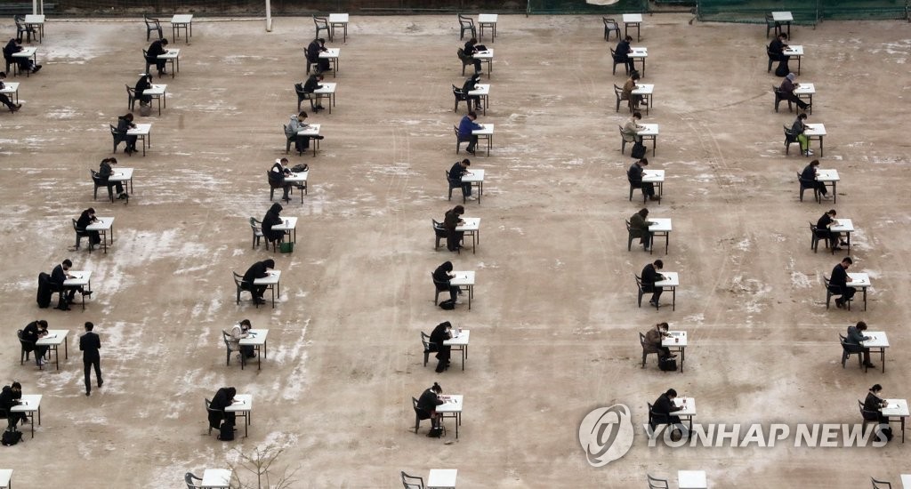 Applicants sitting for an exam on insurance planning are seen seated apart from each other at Myongji College in western Seoul on April 25, 2020. (Yonhap)