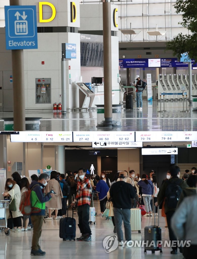 閑散とした仁川国際空（上）と旅行客で混み合う金浦空港＝（聯合ニュース）