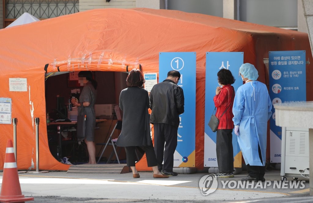 People wait in line to be tested for the new coronavirus at a make-shift clinic at Kangbuk Samsung Hospital in Seoul on May 13, 2020. (Yonhap)