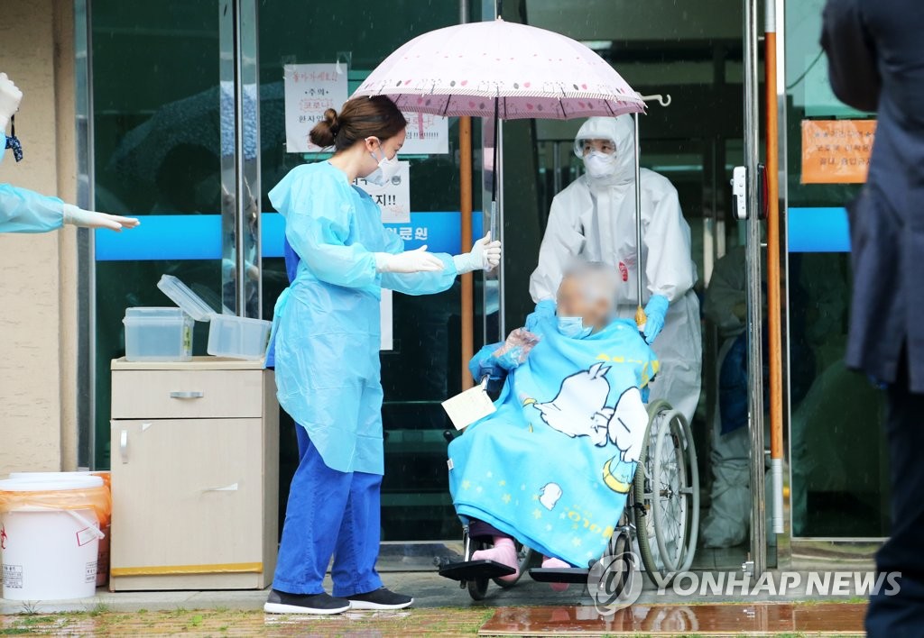In this photo taken on May 15, 2020, a 104-year-old South Korean, identified only by her surname Choi (in wheelchair), is released from a hospital after fully recovering from the new coronavirus. Choi is the oldest South Korean so far to have been infected with the viral disease. (Yonhap)