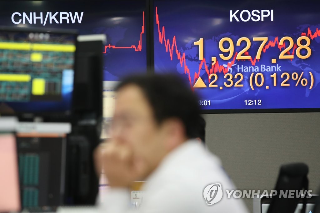 A dealer works in front of an electronic signboard at the headquarters of Hana Bank in Seoul on May 15, 2020. The benchmark Korea Composite Stock Price Index (KOSPI) closed at 1,927.28 points Friday, down 0.95 percent from a week earlier. (Yonhap)