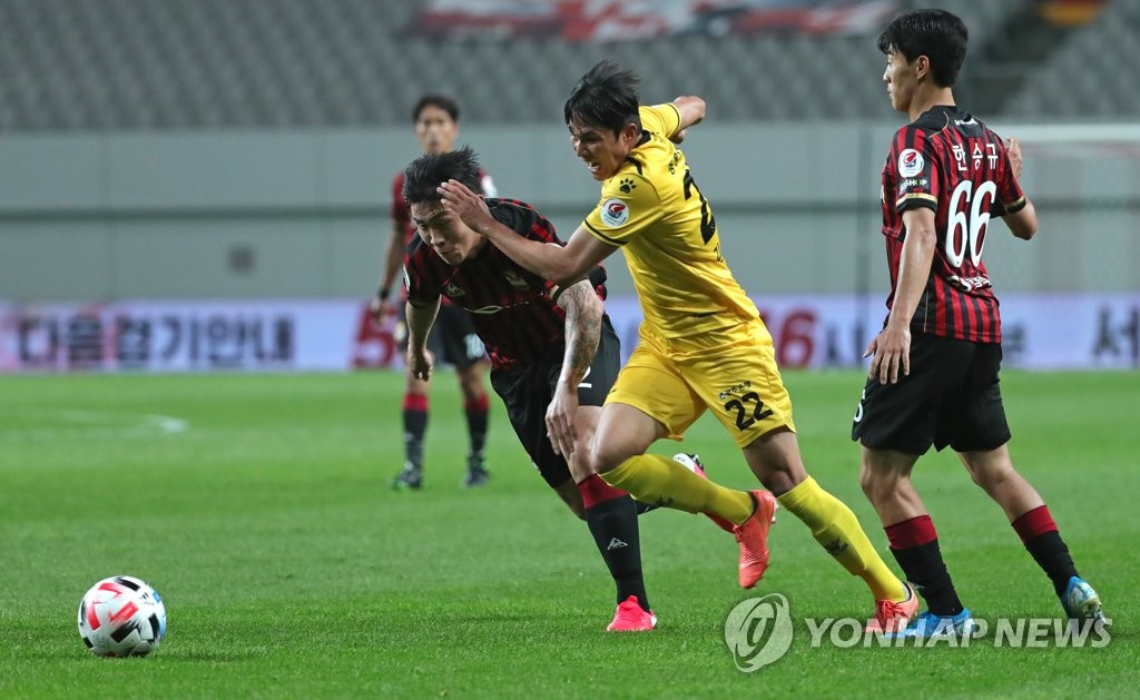 In this file photo, from May 17, 2020, Kim Ju-kong of Gwangju FC (C) chases the loose ball in a K League 1 match against FC Seoul at Seoul World Cup Stadium in Seoul. (Yonhap)