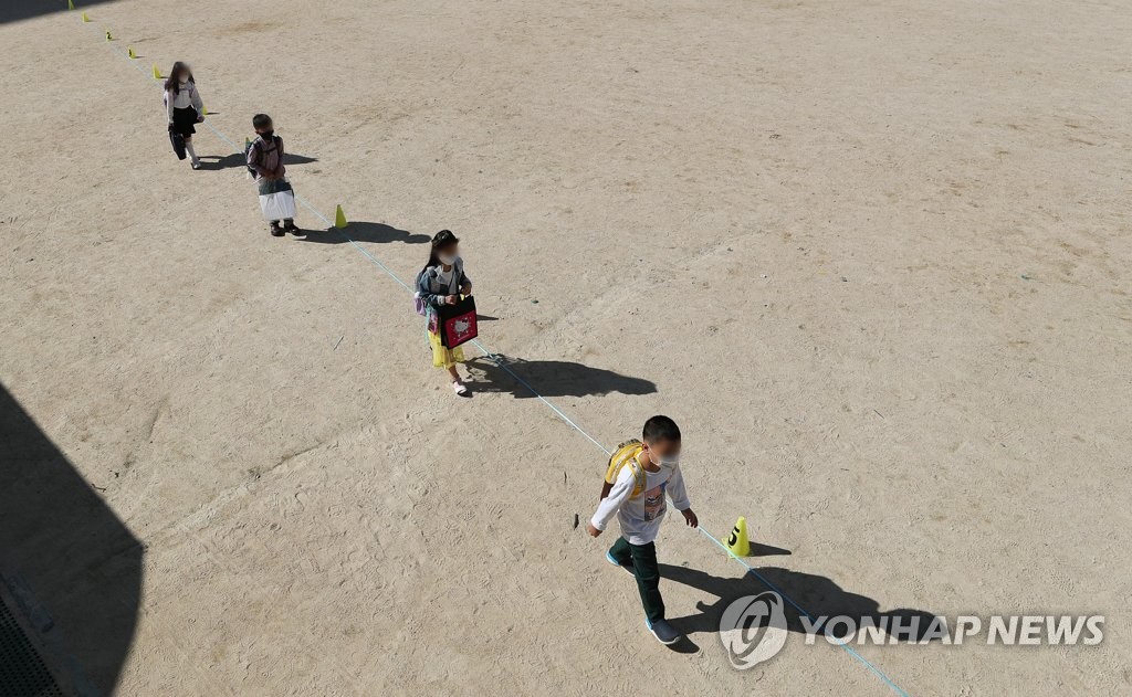 Students walk to school while keeping at a distance from each other in Suwon, south of Seoul, on May 27, 2020. Elementary schools reopened on the day, nearly three months later than usual due to the new coronavirus pandemic. (Yonhap)