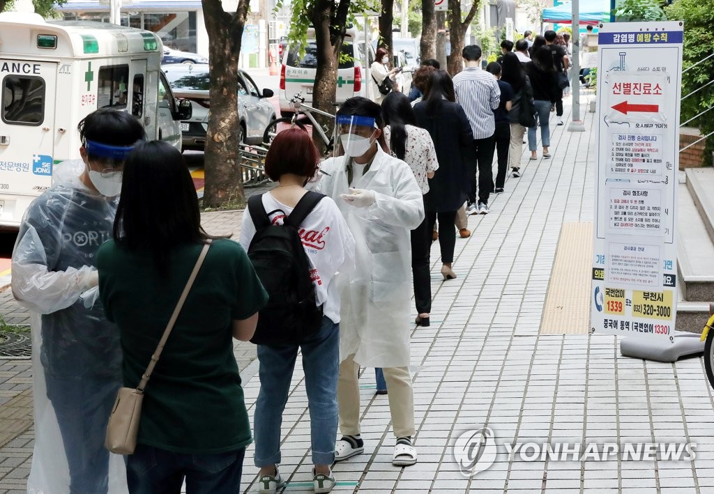 Des gens font la queue le jeudi 28 mai 2020 pour se faire tester dans un centre de dépistage pour le nouveau coronavirus (Covid-19) à Bucheon, à l'ouest de Séoul, dans un contexte où plusieurs cas ont été rapportés dans un centre logistique de l'opérateur d'e-commerce Coupang Inc. dans la ville.