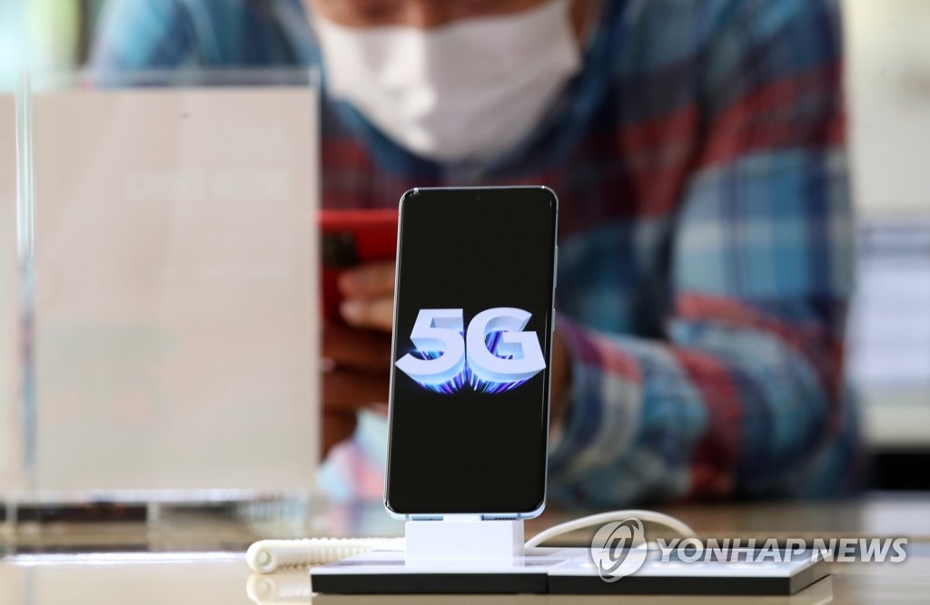 A consumer looks at a 5G phone at a mobile store in downtown Seoul on June 8, 2020. (Yonhap) 