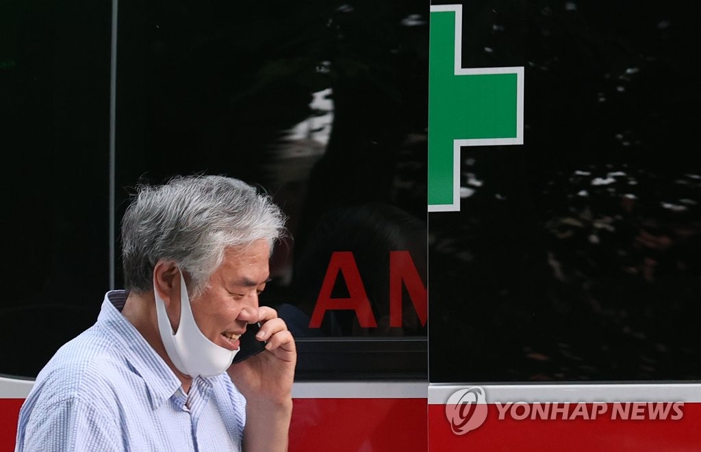 Jun Kwang-hoon, a pastor at Sarang Jeil Church in northern Seoul, talks on the phone before getting into a car run by a local community center on Aug. 17, 2020. Jun tested positive for the new coronavirus. (Yonhap)