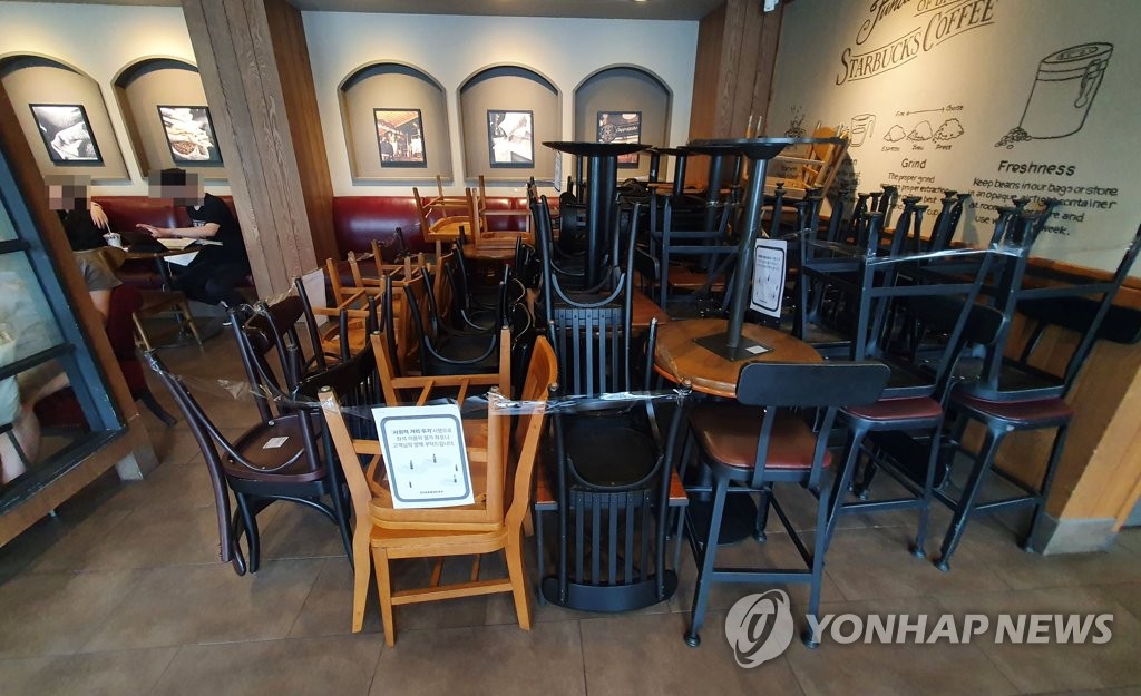 This photo, taken on Aug. 28, 2020, shows chairs and tables stacked up at a franchise coffee chain in Seoul ahead of South Korea's restrictions of operations of restaurants and franchise coffee chains in the greater Seoul area over COVID-19. (Yonhap)