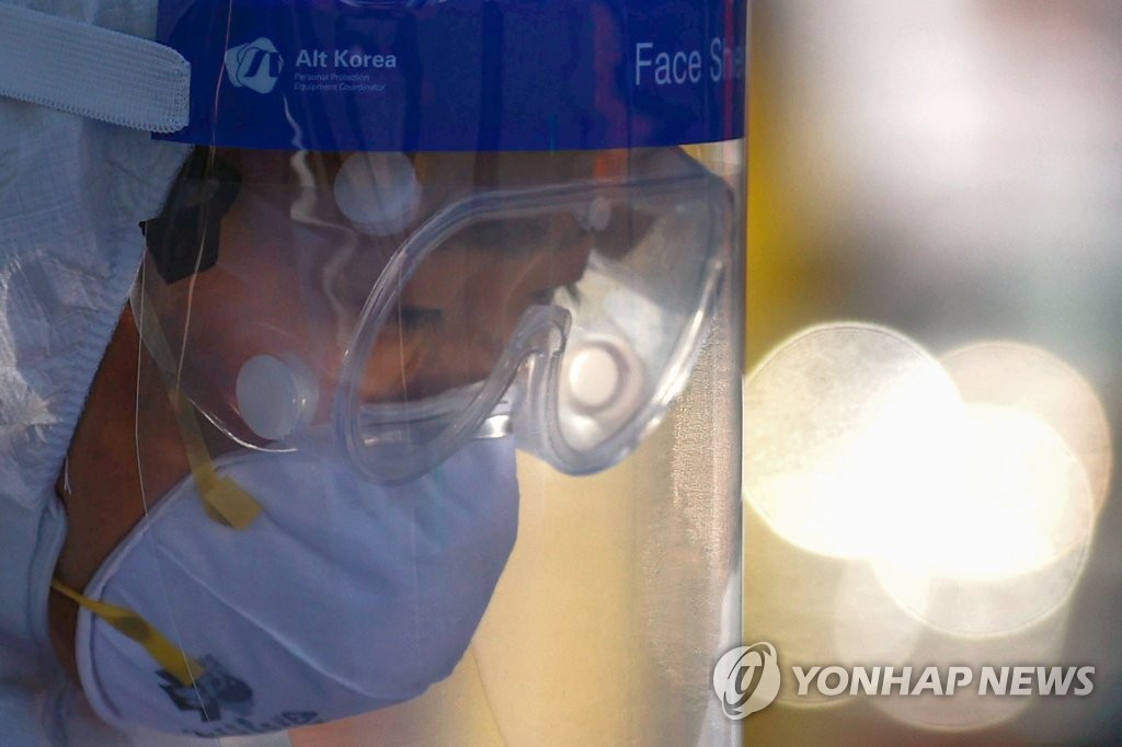 A medical employee works at a makeshift clinic in central Seoul on Dec. 16, 2020. (Yonhap)