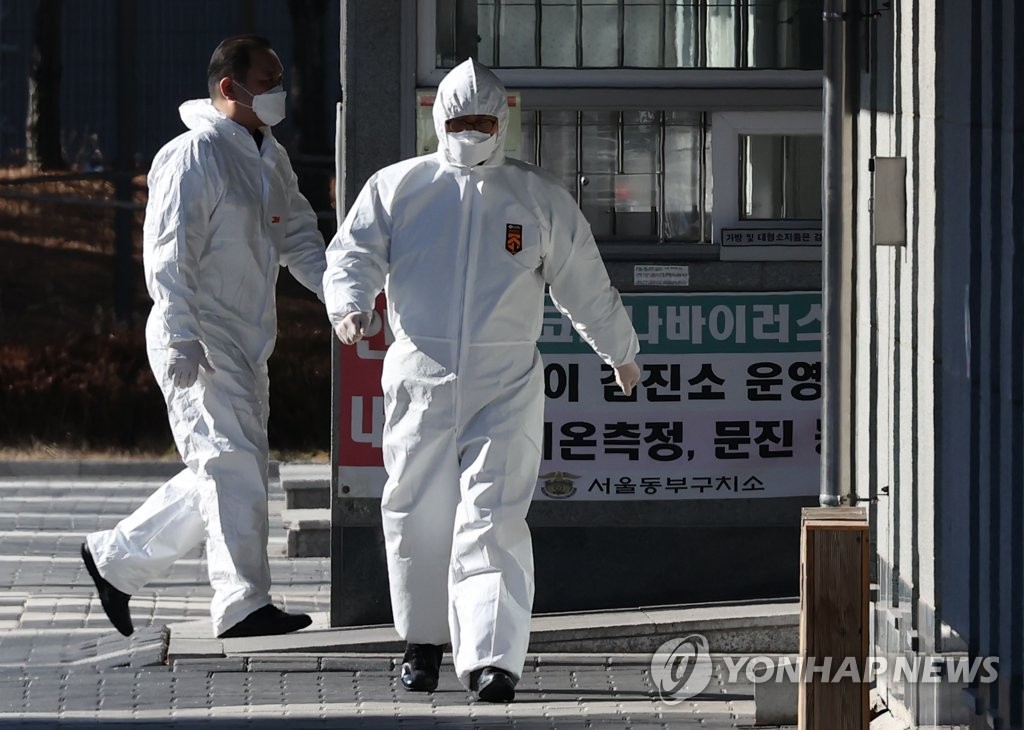Health workers move about in protective gear at a detention center in eastern Seoul on Dec. 20, 2020, where at least 185 new coronavirus cases have been reported. (Yonhap)