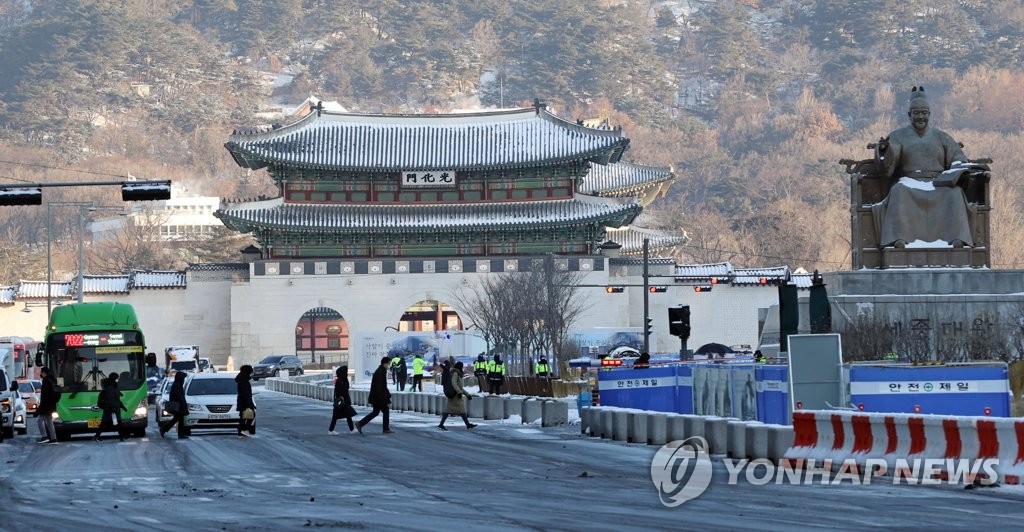 People walk to work in the morning of Jan. 7, 2021, near Gwanghwamun in Seoul. (Yonhap)